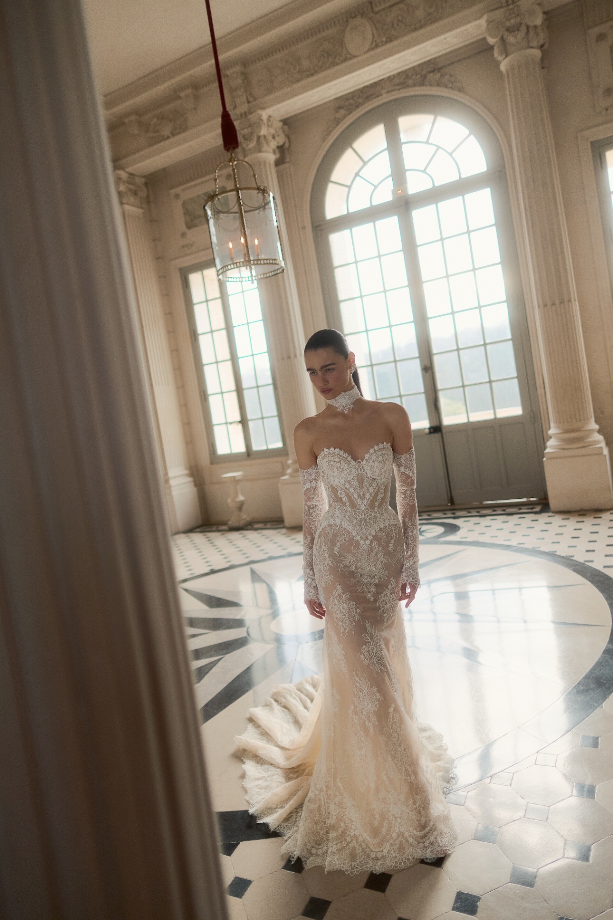 Long-sleeve lace gown in a château ballroom
